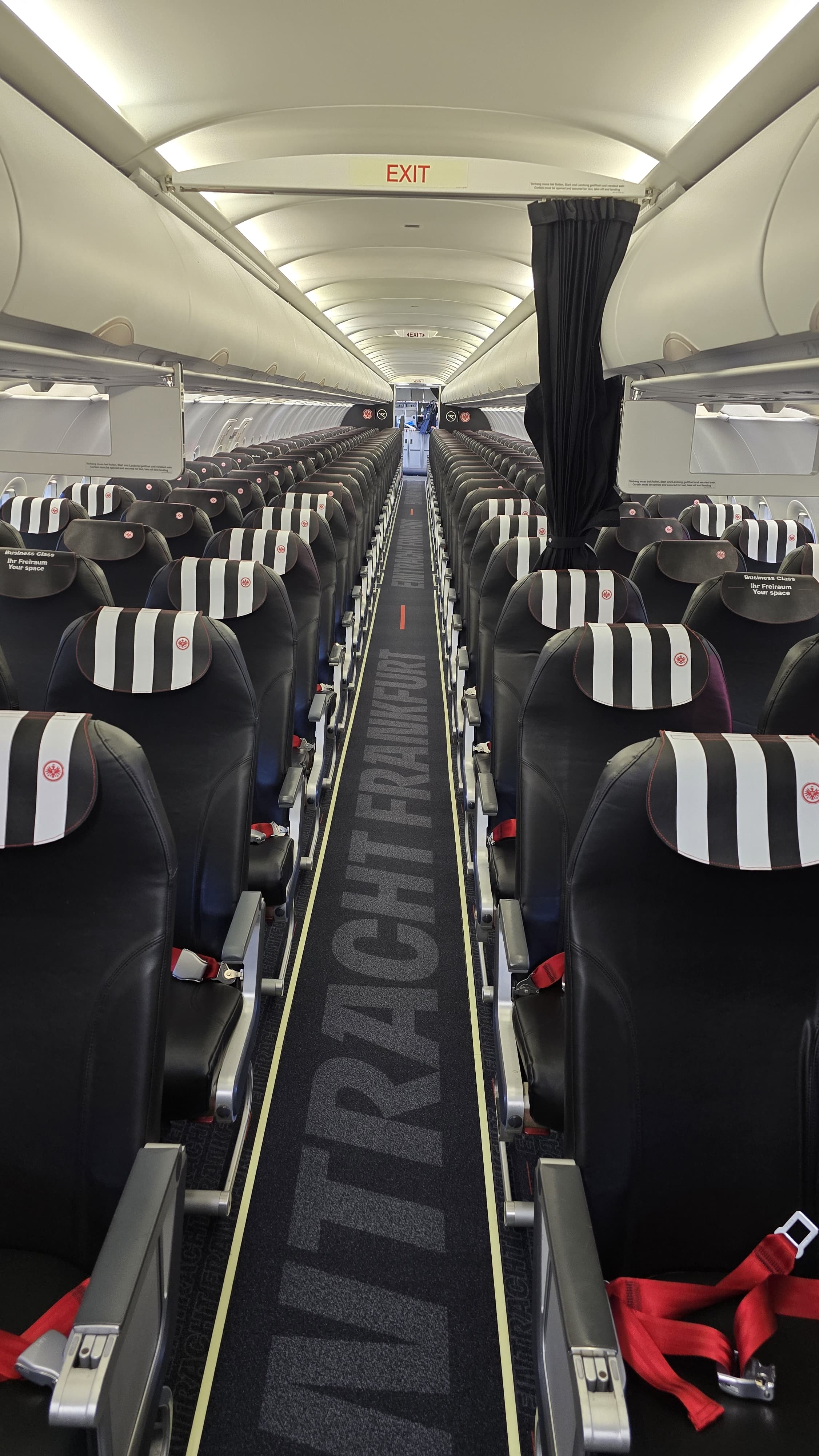 Condor aircraft cabin with bold lettering integrated into the aisle carpet