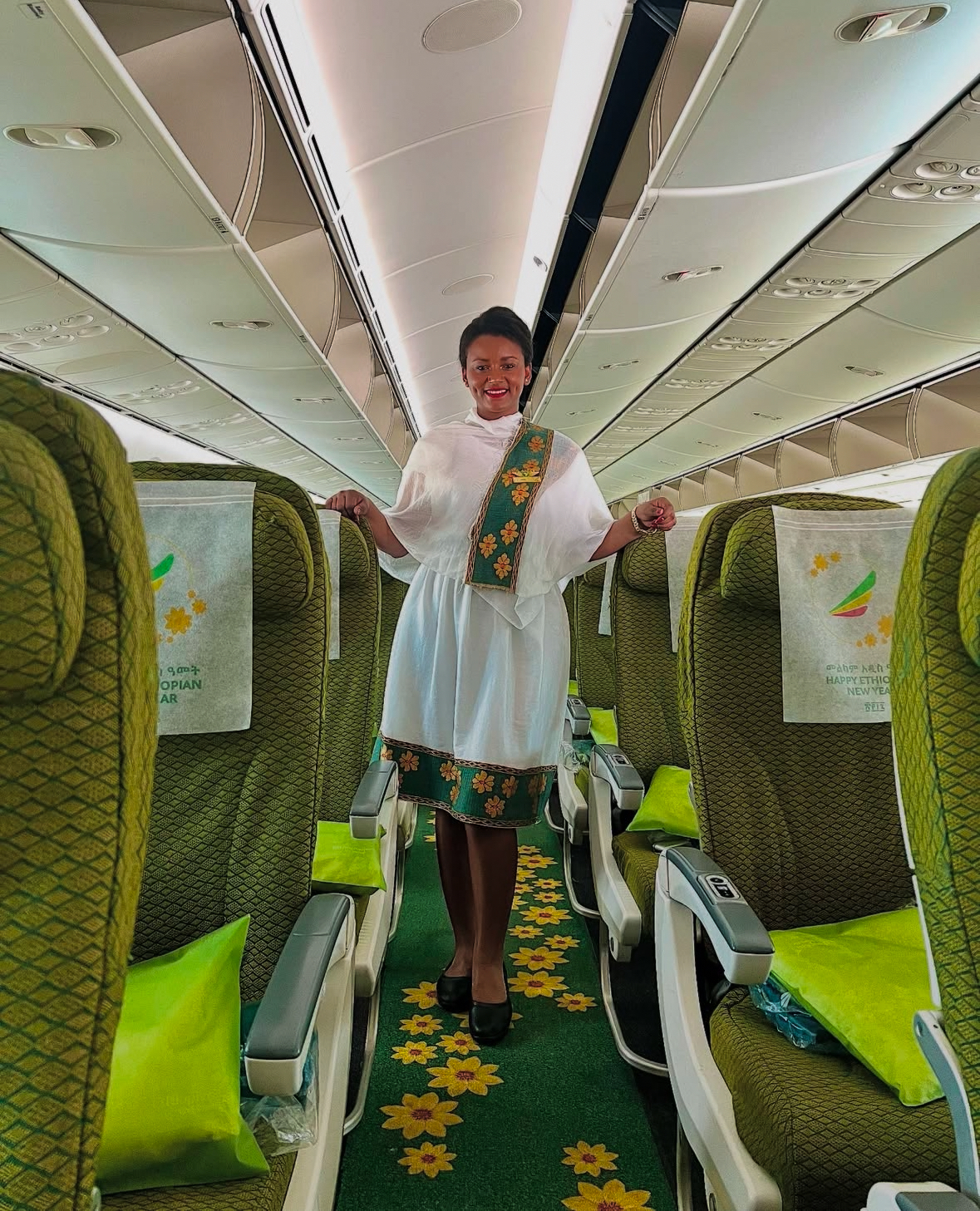Ethiopian Airlines cabin with a green aisle carpet and yellow floral pattern